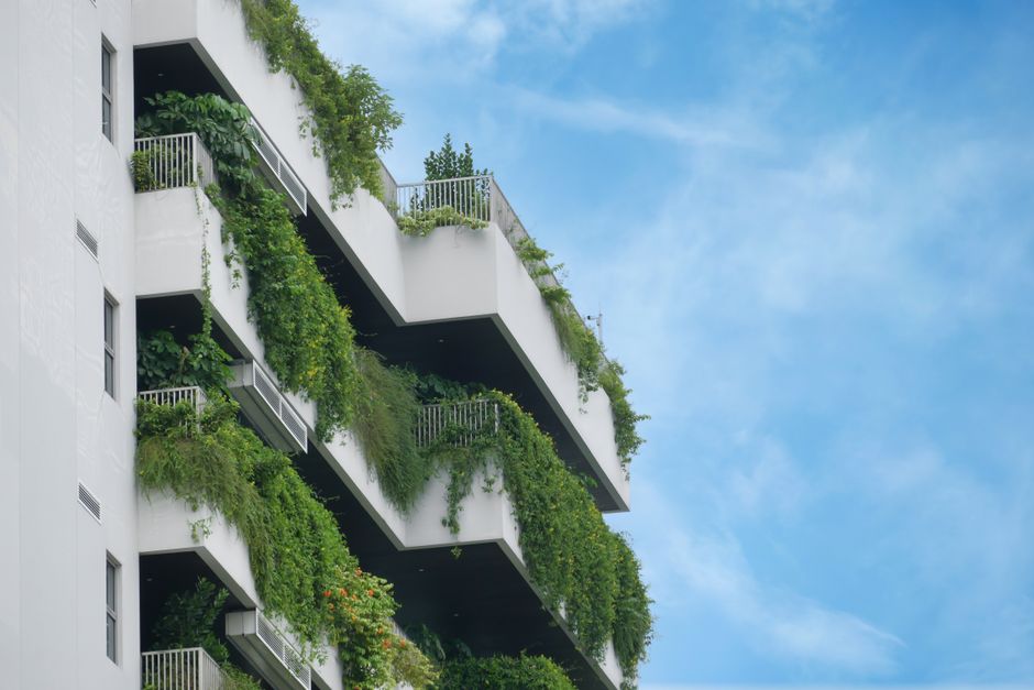Imagem de um edifício residencial com varandas verdes integradas à natureza, representando sustentabilidade urbana e arquitetura sustentável.