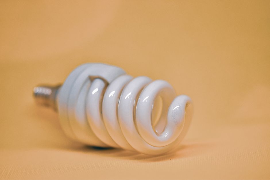 Lâmpada fluorescente compacta (LED) de forma espiral, representando inovação e eficiência energética.