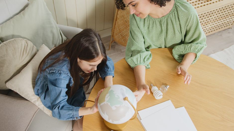 Duas meninas explorando um globo terrestre, representando educação e curiosidade sobre o mundo.