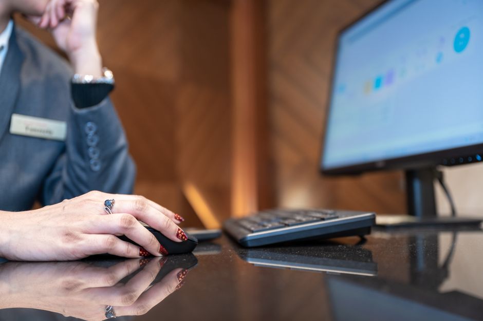 Imagem de uma pessoa usando computador em um ambiente de trabalho, simbolizando produtividade e gestão digital.