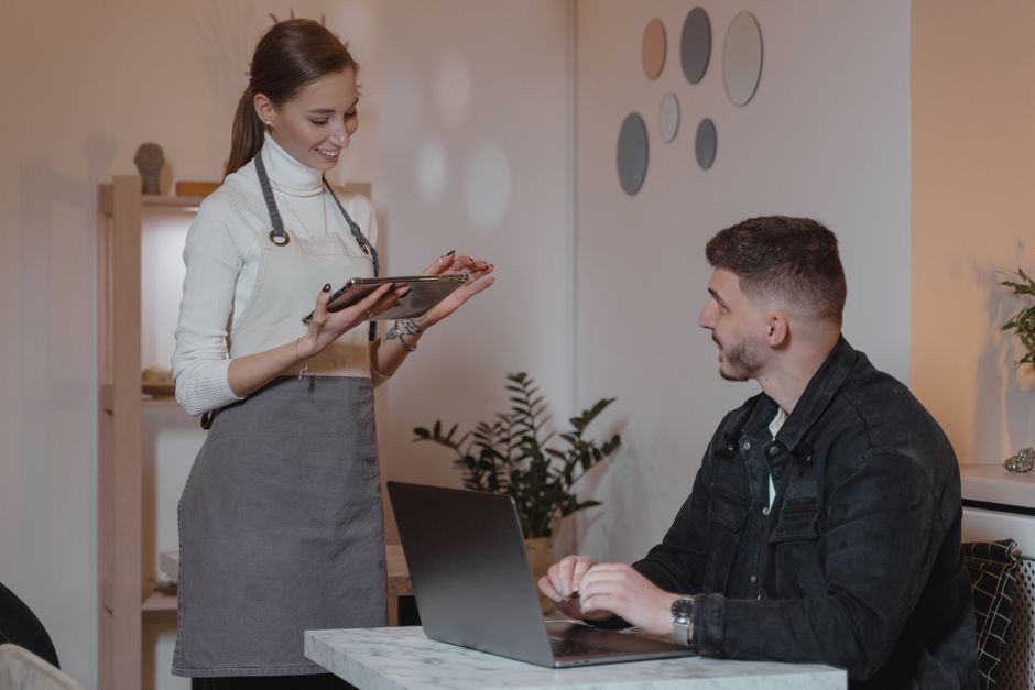 Sessão de atendimento em que uma profissional oferece suporte ou consultoria a um cliente em ambiente de escritório ou coworking.