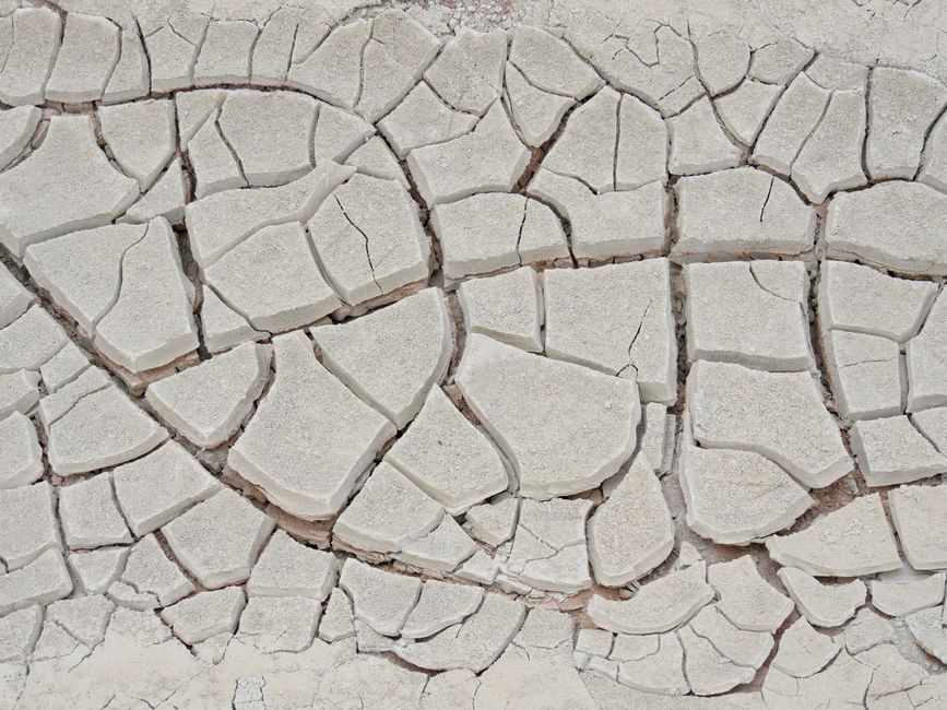 Imagem de uma parede de cimento rachada, com detalhes das fissuras, simbolizando fragilidade estrutural ou desgaste. 