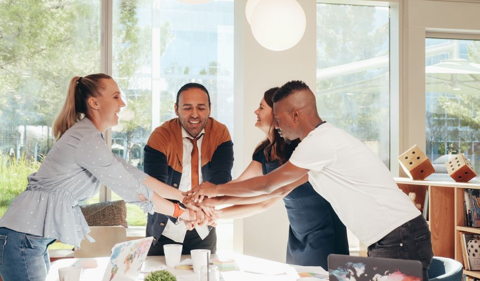 Grupo de colegas celebrando uma conquista no ambiente de trabalho com integração e entusiasmo.