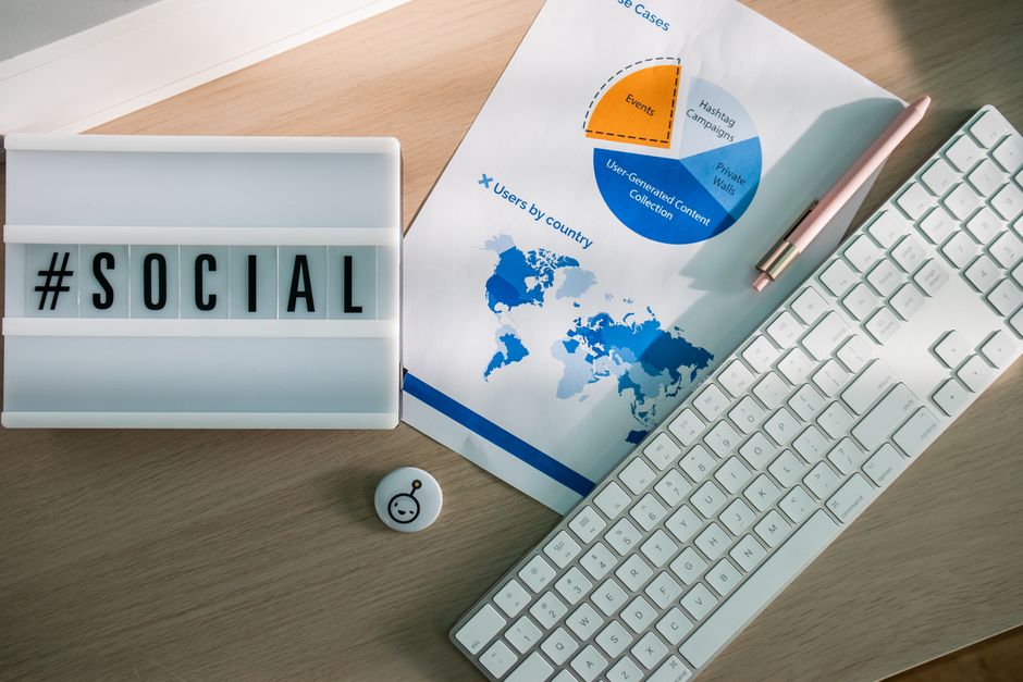 Imagem de escritório com materiais de trabalho relacionados ao marketing digital e análise de dados para estratégias de redes sociais.