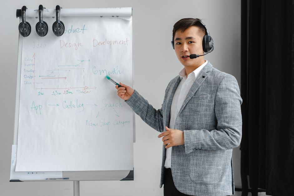 Homem apresentando conceitos de desenvolvimento de produto em uma palestra de negócios, com foco na estratégia e inovação.