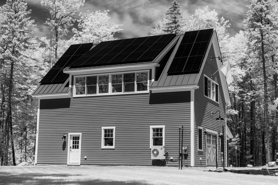 Casa com painéis solares em uma área de floresta, destacando sustentabilidade e energia renovável para blogs sobre inovação e meio ambiente.