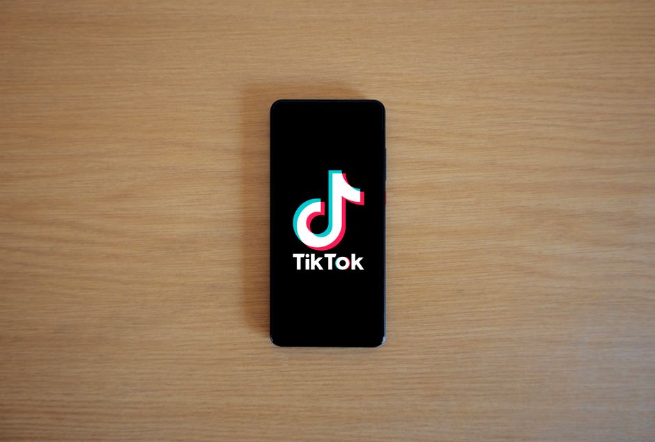 Smartphone exibindo o logo do TikTok, destacando a presença da plataforma de vídeos em um ambiente digital.