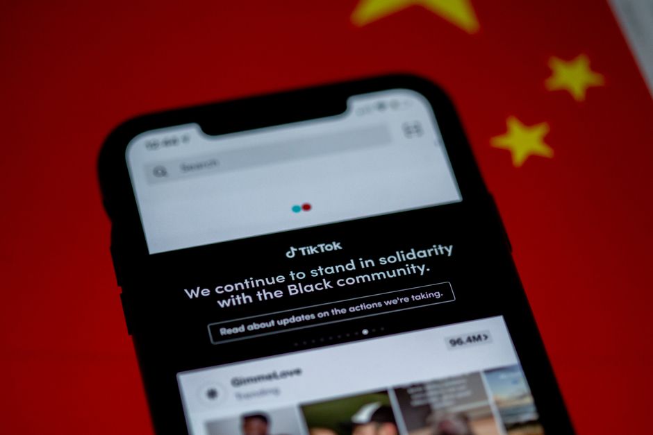 Imagem de um smartphone exibindo uma campanha de solidariedade em apoio à comunidade negra, sobre um fundo vermelho com estrelas amarelas, simbolizando ativismo e conscientização social.