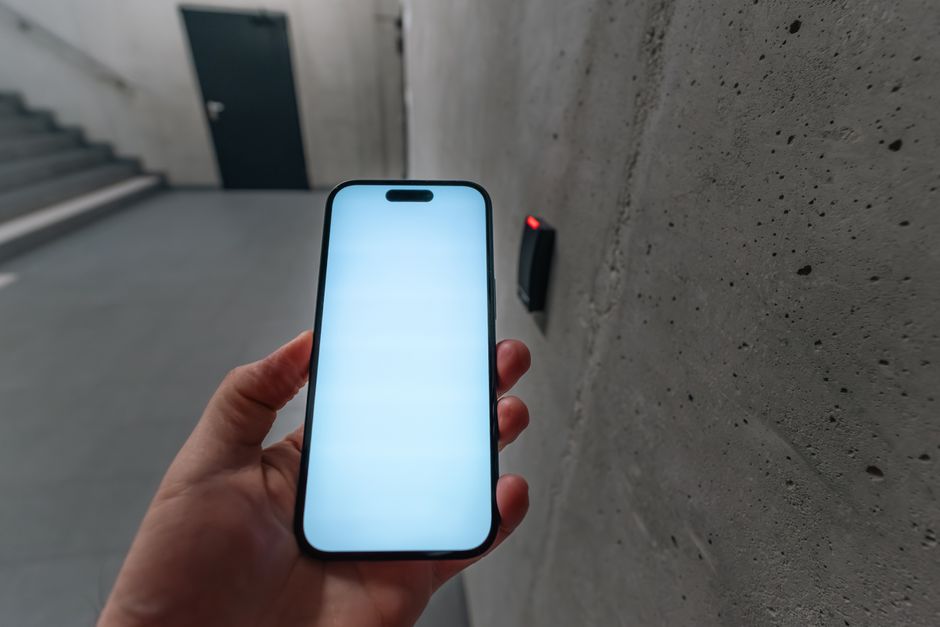 Pessoa segurando um smartphone em um ambiente urbano, simbolizando tecnologia e conexão digital.