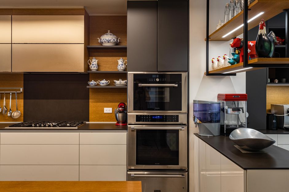 Cozinha moderna com eletrodomésticos embutidos e decoração delicada, ideal para discutir tendências de design de interiores e organização de cozinhas.
