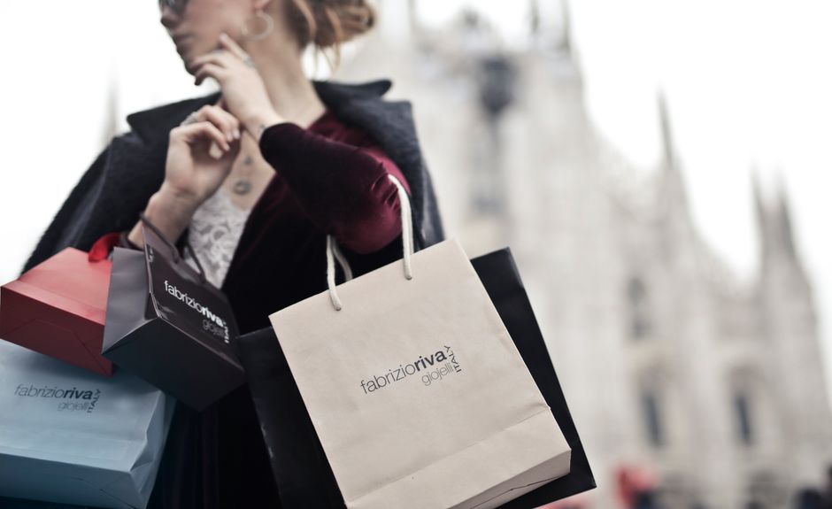 Mulher com sacolas de compras em ambiente urbano, representando consumo, moda ou lifestyle na cidade