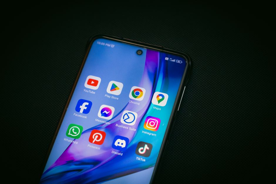 Imagem de um smartphone exibindo diversos aplicativos de redes sociais e serviços online, representando conectividade digital e comunicação moderna.