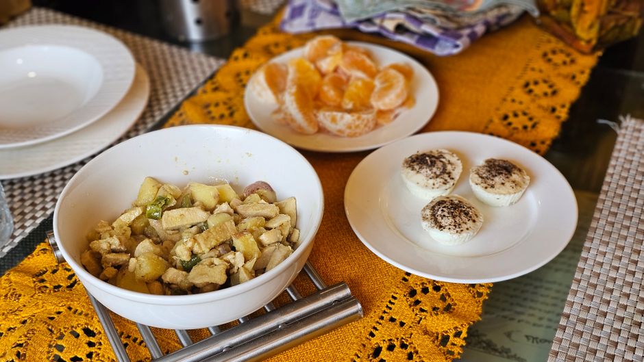 Refeição caseira com salada de batatas, sobremesas e ovos de iogurte, ideal para um café da manhã ou lanche.