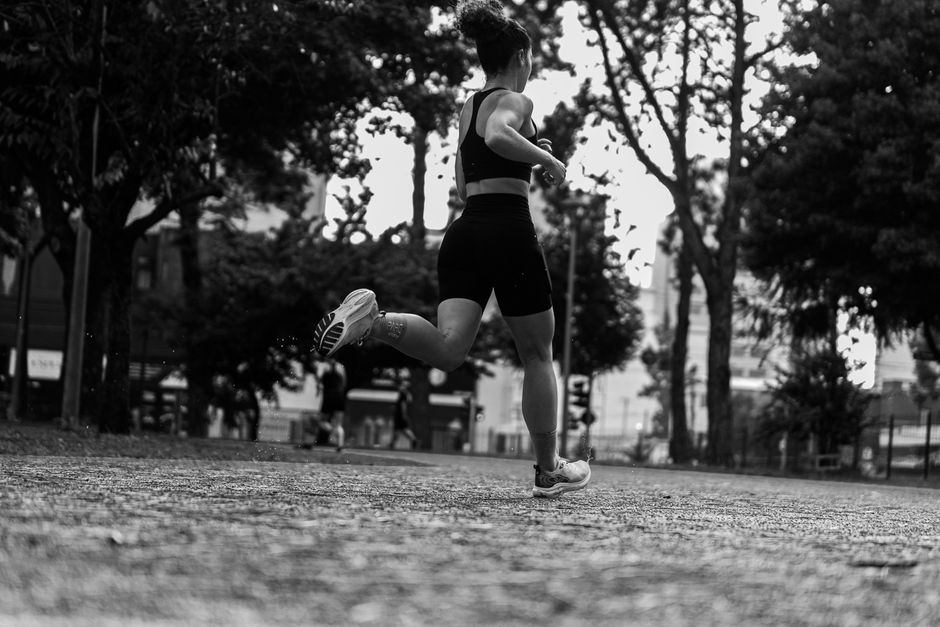 Mulher correndo ao ar livre, simbolizando saúde, bem-estar e exercícios físicos