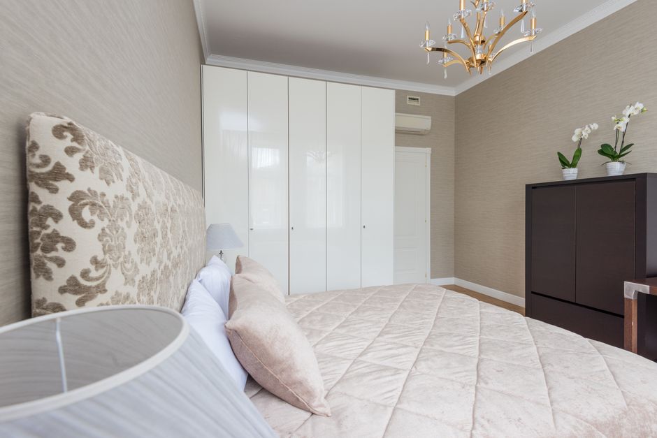 Quarto residencial bem decorado com cama confortável, ar-condicionado e elementos de foco na decoração de interiores.