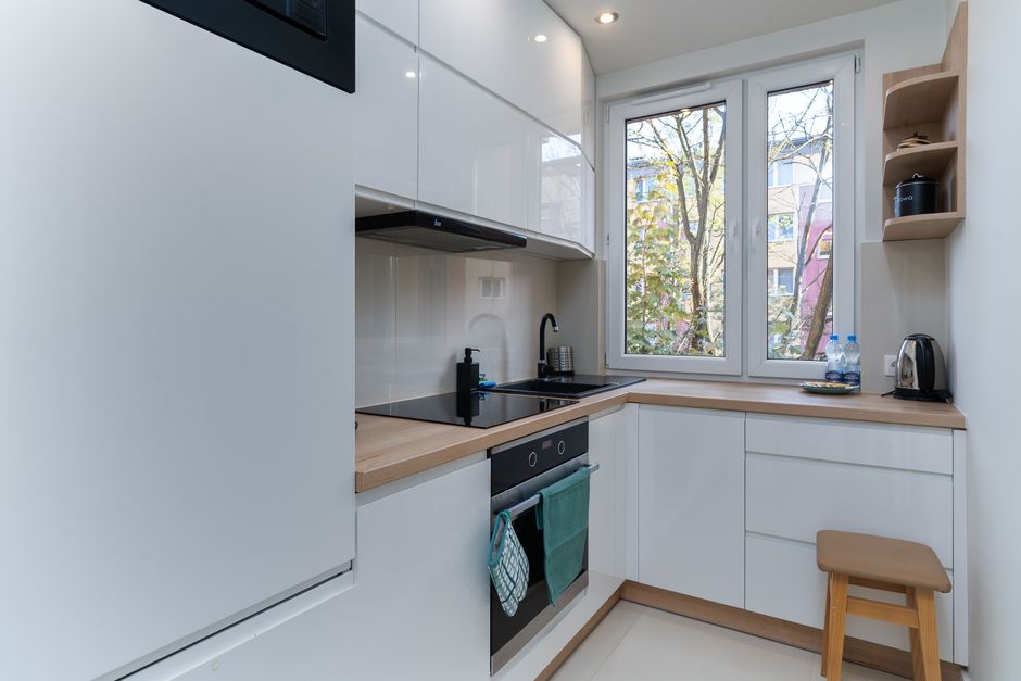 Cozinha moderna com design clean e janelas que oferecem iluminação natural, ideal para espaço de convivência e preparação de refeições.