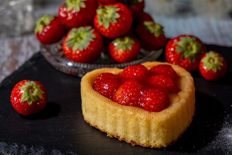 Imagem de uma torta de morango recém-preparada, decorada com morangos frescos, ideal para um blog de receitas ou gastronomia.