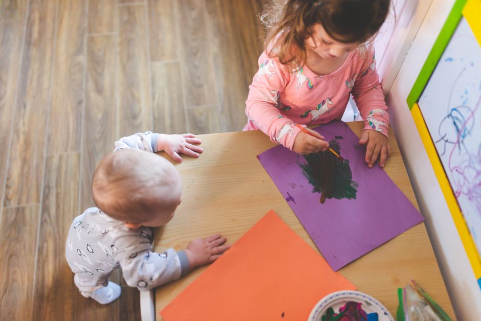Duas crianças pintando juntas em uma atividade criativa em sala de aula, promovendo o desenvolvimento infantil e a expressão artística.