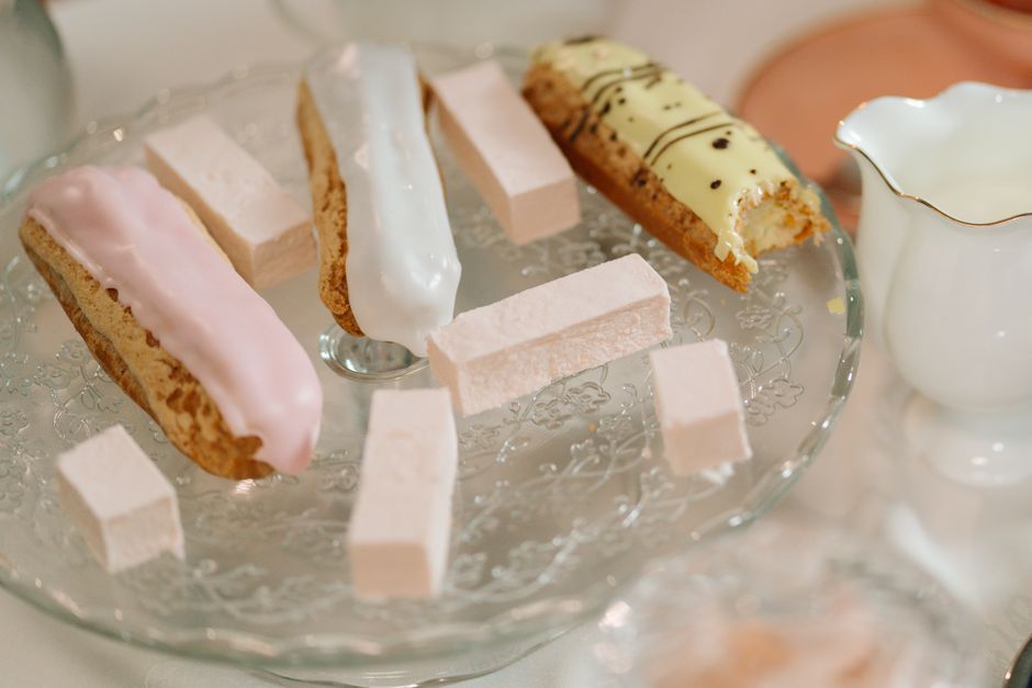 Doces e biscoitos delicados dispostos em uma travessa de vidro para um momento de lanche ou chá.