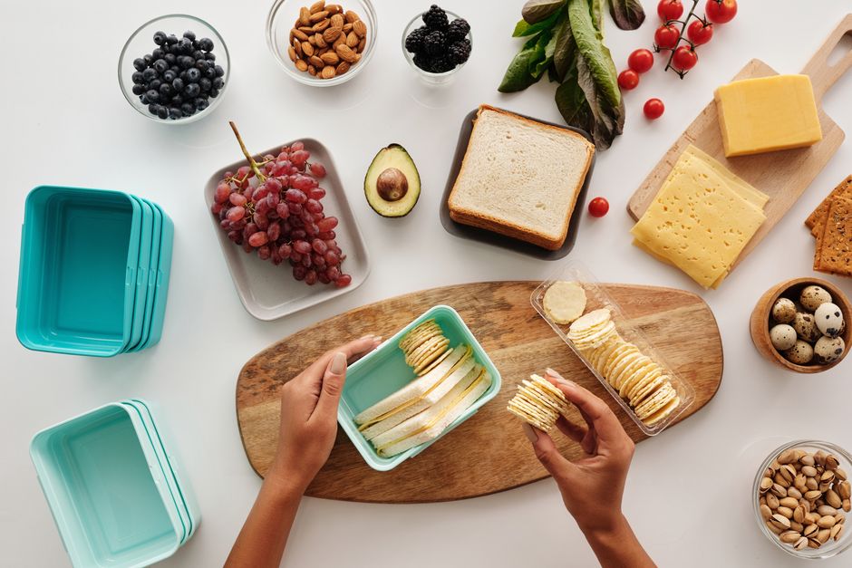 Cena de uma variedade de alimentos saudáveis como frutas, queijos e biscoitos dispostos sobre uma mesa, ideal para um post sobre alimentação equilibrada.