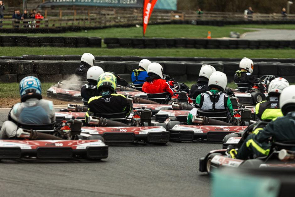 Grupo de participantes em uma corrida de kart, mostrando a emoção e o espírito competitivo do esporte.