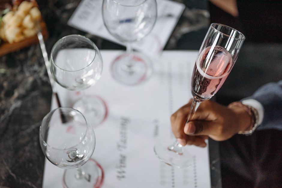 Pessoa celebrando ou brindando com taças de champanhe em um ambiente elegante, possivelmente durante um evento social ou celebração.
