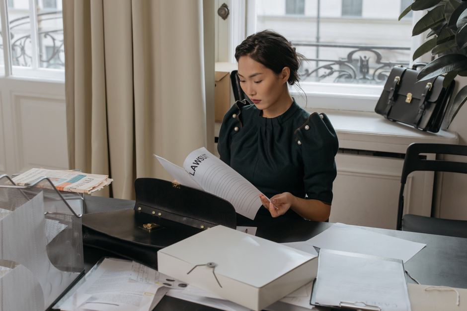 Mulher analisando documentos legais em um ambiente de escritório com foco em direito ou consultoria jurídica.