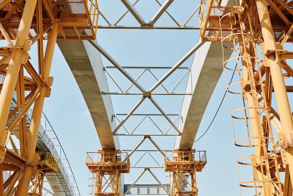 Imagem de uma estrutura de ponteira de construção em metal, destacando a engenharia e o avanço de obras civis.