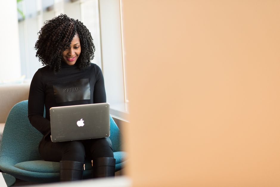 Mulher usando laptop em ambiente de trabalho, transmitindo produtividade e conexão digital.