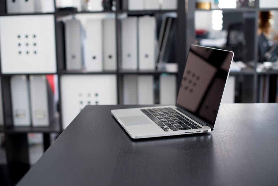 Imagem de um ambiente de trabalho moderno com um notebook em uma mesa de escritório, sugerindo foco em tecnologia e produtividade empresarial.