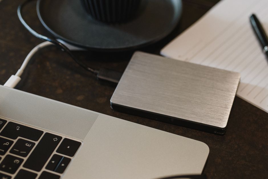 Imagem de um espaço de trabalho com laptop, bloco de notas, caneta e acessórios de escritório, ideal para artigos sobre produtividade e organização profissional.
