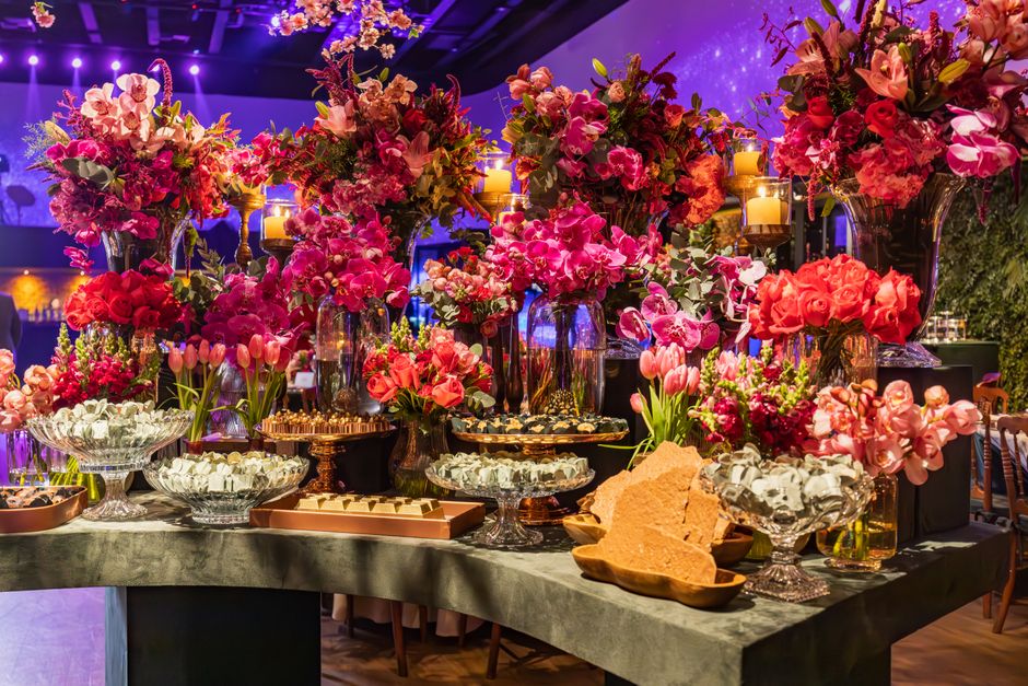 Mesa decorada com flores e velas em um evento sofisticado e elegante.