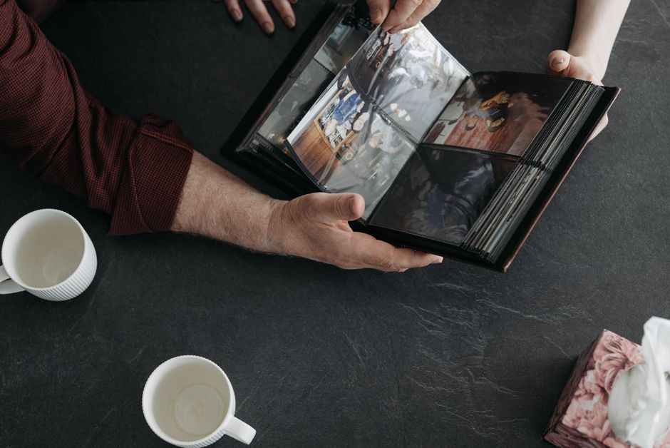 Pessoa folheando um álbum de fotos, simbolizando memórias e momentos especiais.