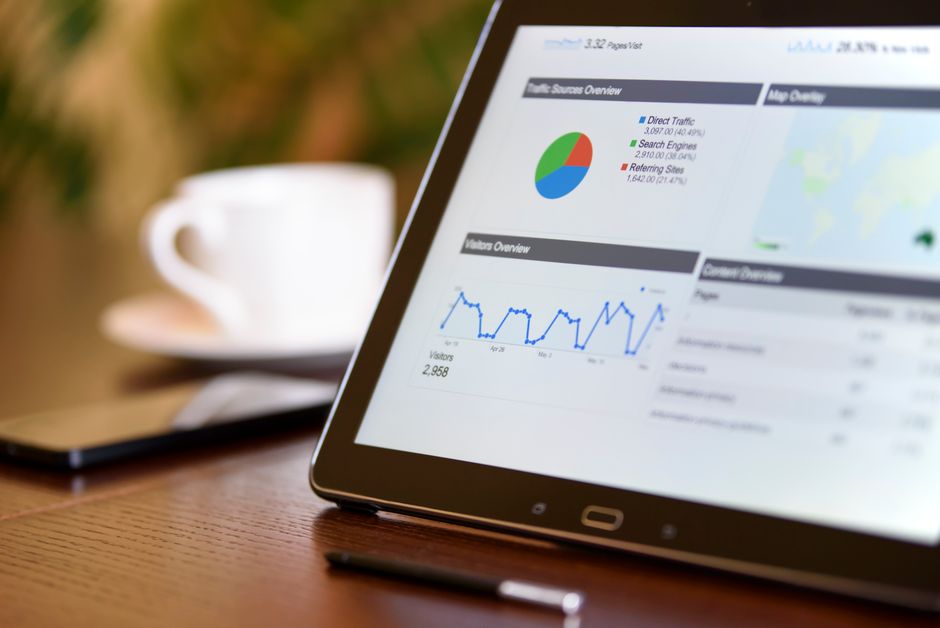 Imagem de um tablet exibindo gráficos e dados analíticos relacionados à internet e tráfego de visitantes, ideal para artigos sobre marketing digital e análise de desempenho online.