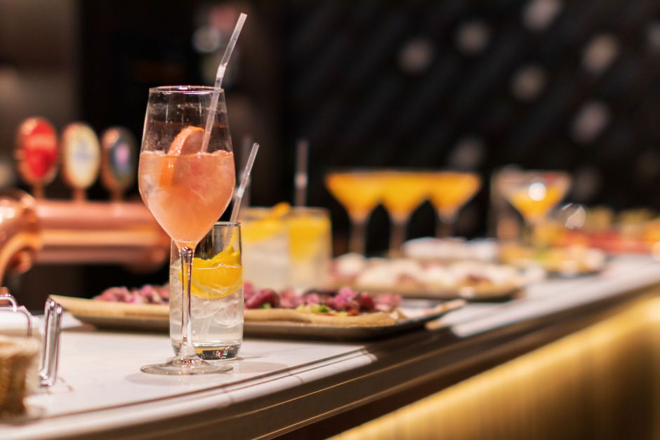 Imagem de um bar com drinks coloridos e petiscos, ideal para ilustrar o tema de eventos sociais ou festas em restaurante.