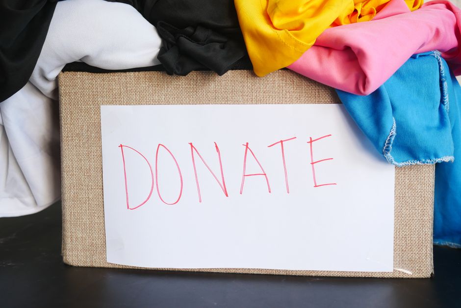 Caixa de doações com roupas arrecadadas para campanha solidária, simbolizando ajuda e solidariedade.