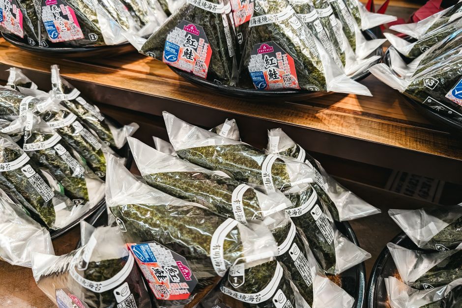 Pacotes de algas marinhas sob prateleira, prontos para venda, em uma loja de produtos alimentícios orientais.