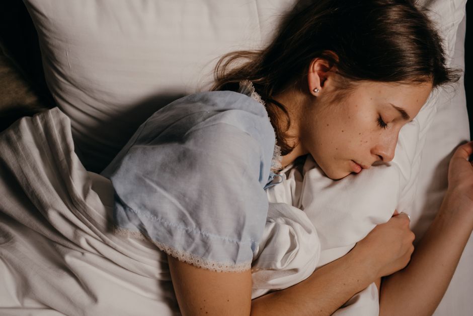 Mulher dormindo com expressão relaxada, mostrando uma cena de descanso e bem-estar.