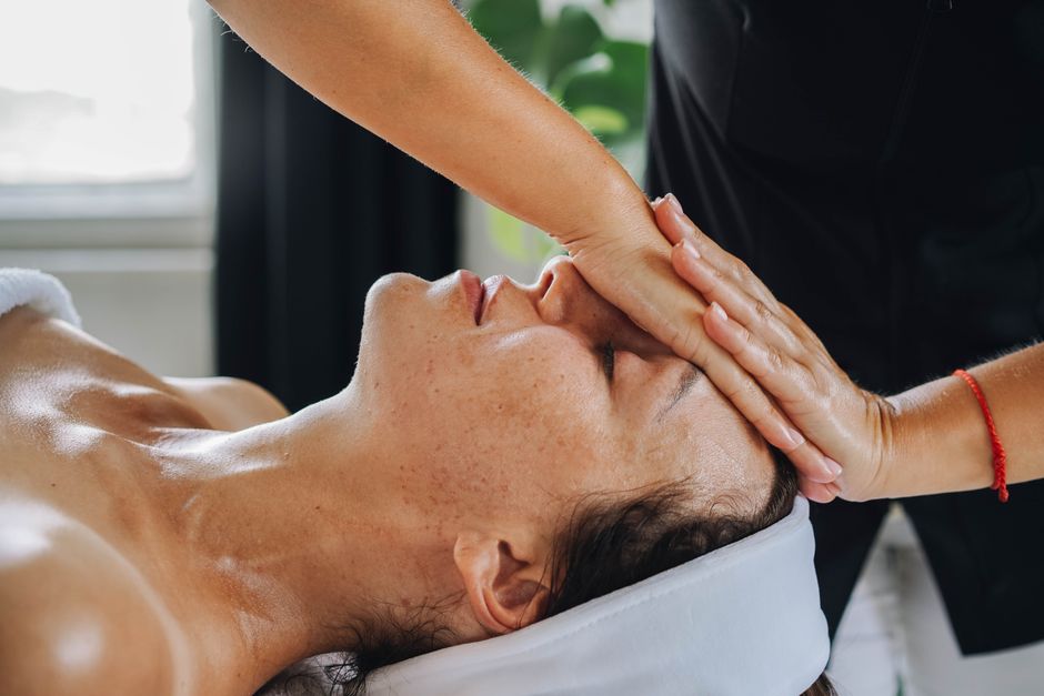 Pessoa recebendo uma sessão de terapias de beleza ou relaxamento, possivelmente massagem facial ou Tratamento Spa.