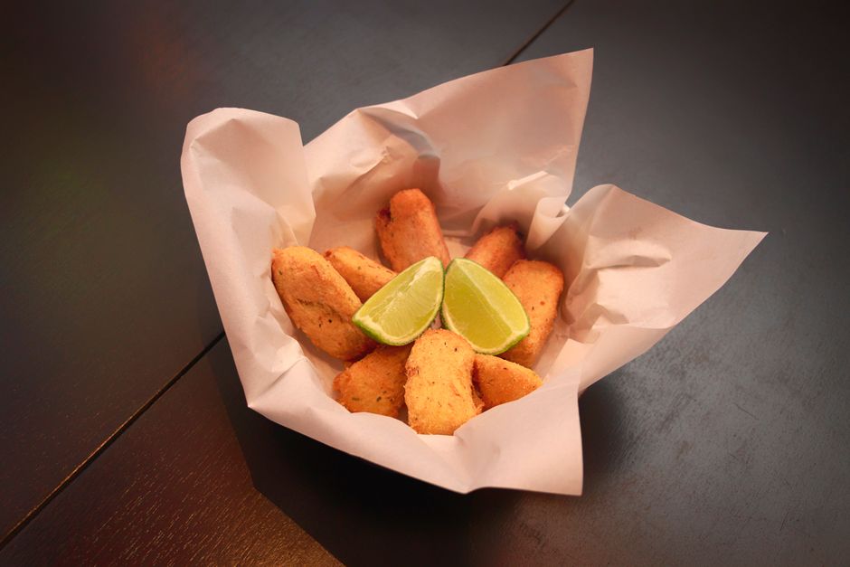 Porção de filés de peixe empanados acompanhados de fatias de limão, ideal para abordagens sobre culinária, petiscos ou gastronomia de frutos do mar.