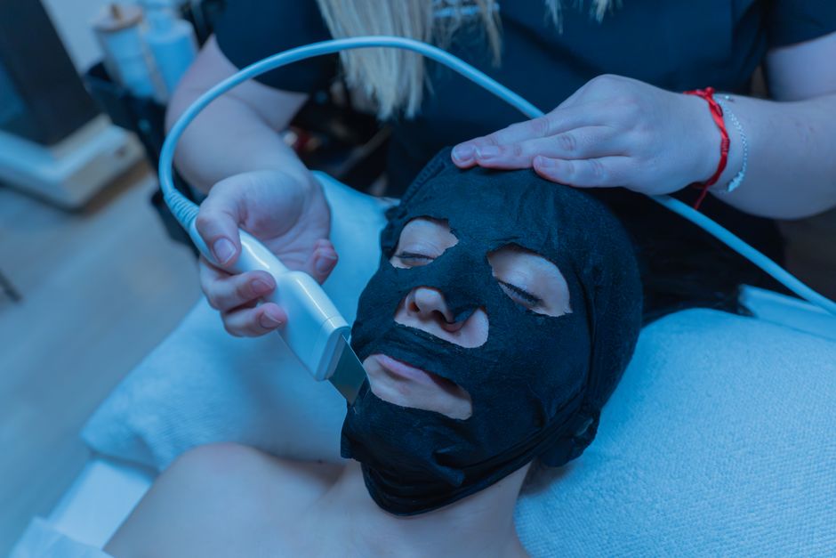 Tratamento de limpeza facial realizado com máscara e aparelho de ultrassom, em ambiente de estética facial.