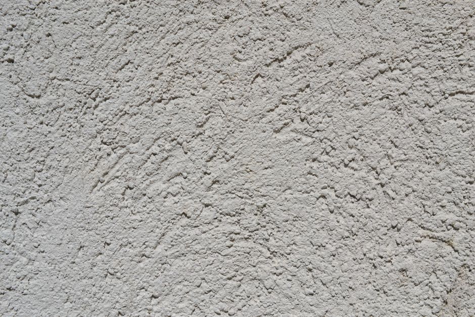 Superfície de parede de textura rugosa e ondulada, ideal para ilustrar materiais relacionados a construção ou decoração.