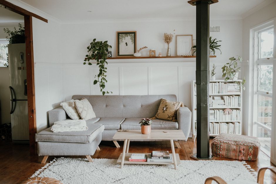 Imagem de uma sala de estar moderna e aconchegante, com decoração minimalista e detalhes naturais.