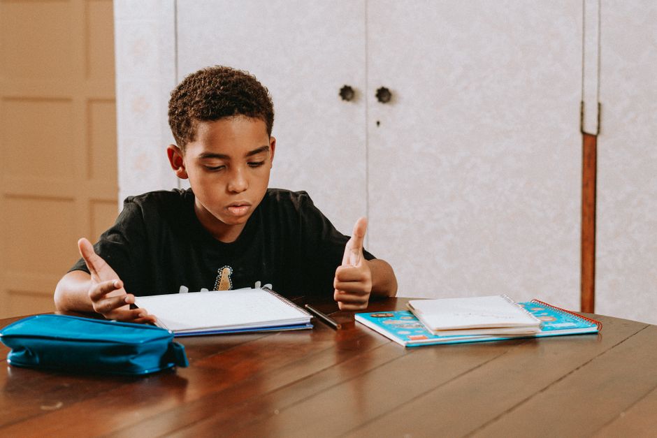 Criança estudando e demonstrando confiança ao fazer tarefas escolares, ideal para artigos sobre educação infantil ou motivação aos estudos.
