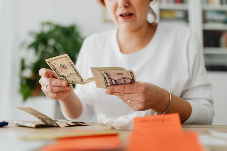 Pessoa contando dinheiro, ilustrando tema de finanças pessoais e gestão de recursos.