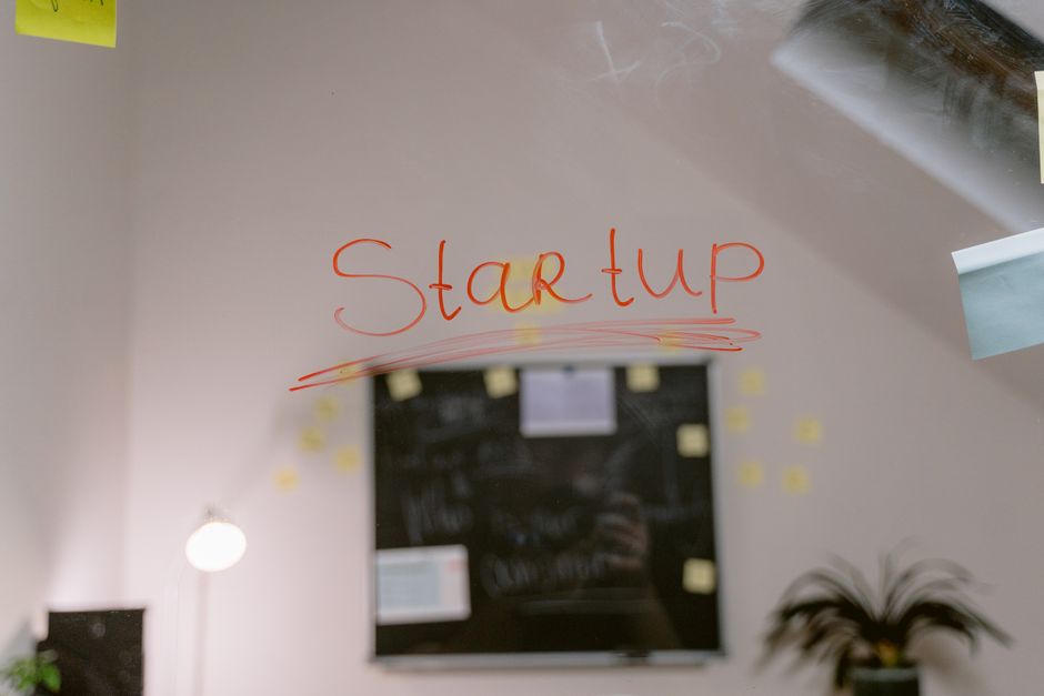 Quadro de vidro com a palavra 'Startup' escrita em destaque, simbolizando inovação e empreendedorismo.