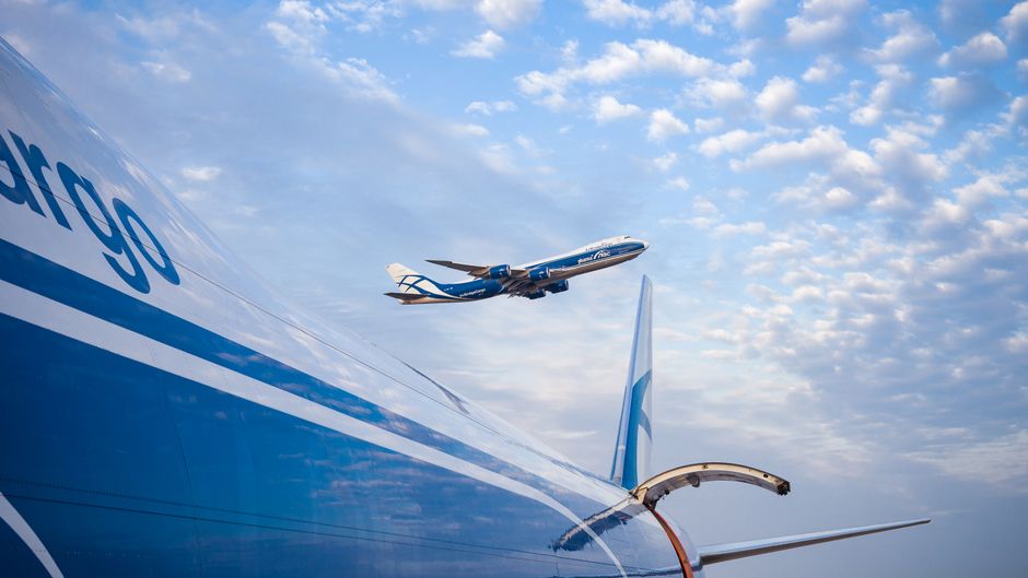 Imagem de aviões no céu mostrando operações de transporte aéreo de passageiros e cargas.