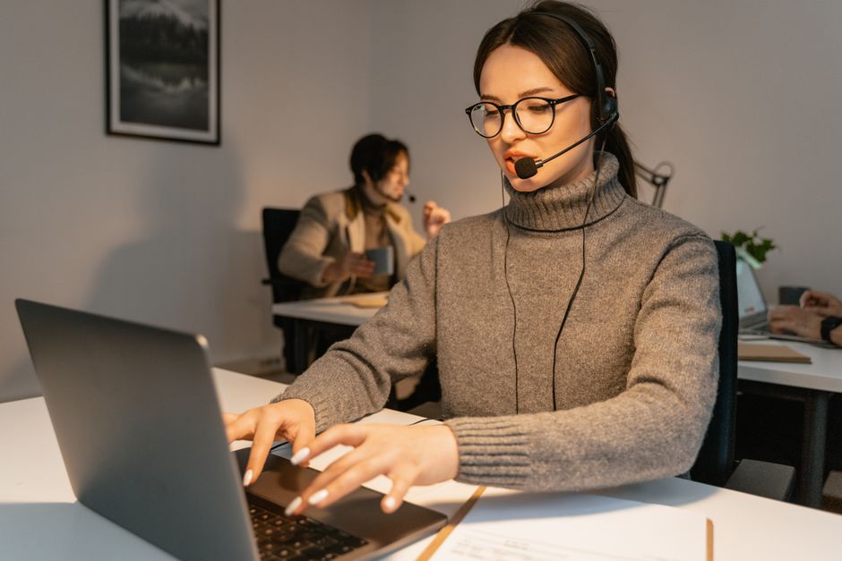 Mulher atendendo ao cliente em um call center, demonstrando atendimento ao cliente ou suporte remoto.