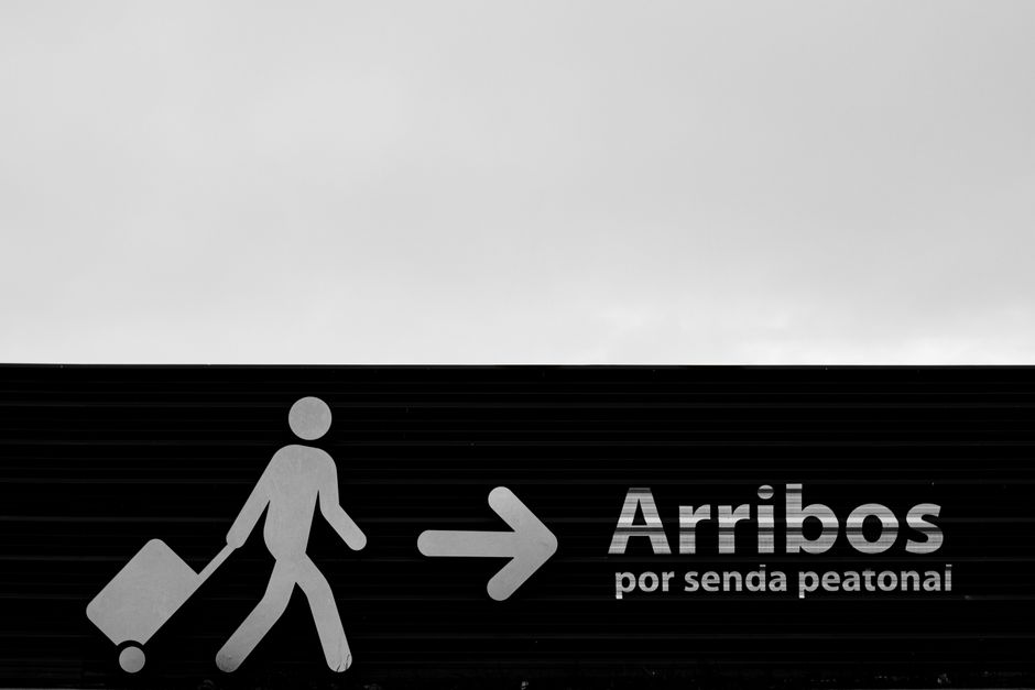 Sinalização indicando a direção para pedestres que desejam subir por uma passarela ou ponte de pedestres.