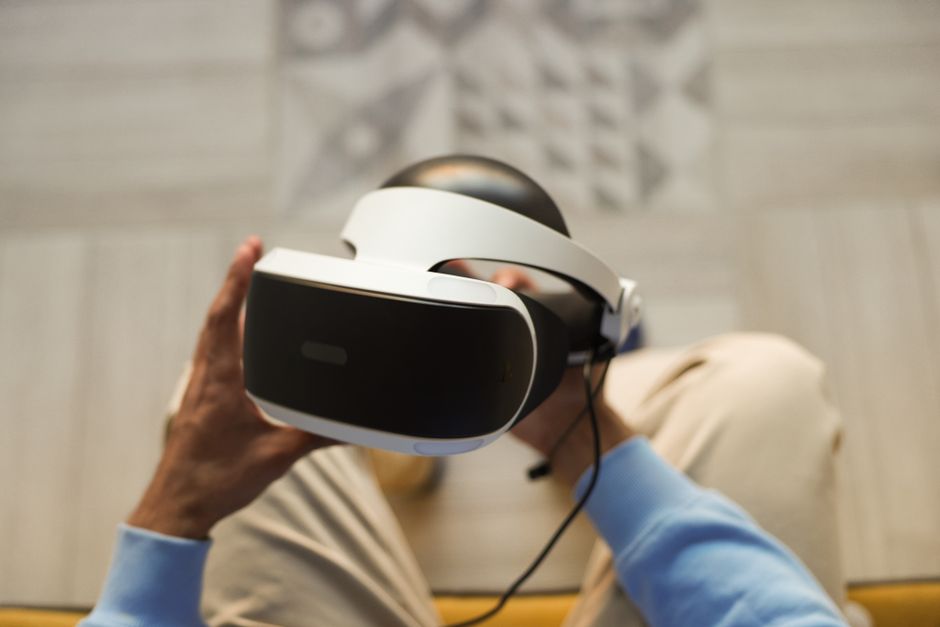 Pessoa interagindo com um headset de realidade virtual, simbolizando inovação tecnológica e experiências imersivas.